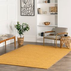 there is a yellow rug in the living room with chairs and a potted plant