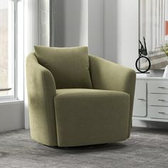 a green chair sitting in front of a window on top of a carpeted floor