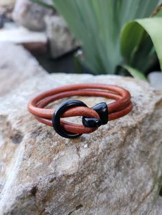 Brown leather with orange tones bracelet with a black circle hook clasp. Very unique looking bracelet.  Measures at 8 inches and would best fit wrists measured at 7.40 inches or less. My wrist (in photo) is 6.50 inches for reference. To measure your wrist size, take a string, wrap it around your wrist and mark where it meets. Lay it flat on a tape measure and you have your length! Most wrists range from 6.50 inches to 7.25 inches. Wedding Bracelets, Black Circle, Orange Tones, Wedding Jewelry Bracelets, Hook Clasp, Tape Measure, Wedding Bracelet, Leather Bracelet, Wedding Jewelry