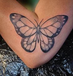 a woman's thigh with a butterfly tattoo on it