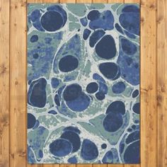 a blue and white area rug on top of a wooden floor next to a wall