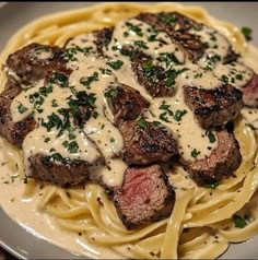 steak with sauce and noodles on a white plate, ready to be eaten at the table