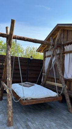 a wooden swing bed sitting on top of a patio