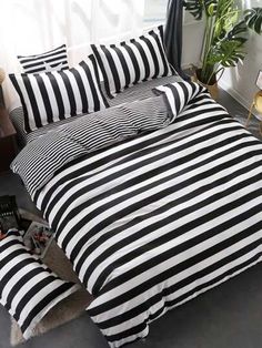 black and white striped bedding in a bedroom with plants on the side walk way