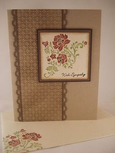 a card with flowers on it sitting next to a white envelope