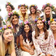 a group of women with flower crowns on their heads posing for a photo in front of the camera