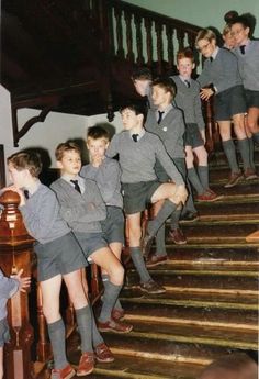 a group of young boys standing on top of a set of stairs next to each other