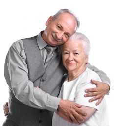 an older couple embracing each other in front of a white background with the man holding his arm around the woman's shoulder