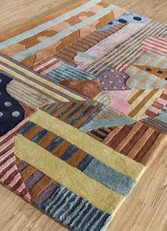 a multicolored area rug with various shapes and sizes on the floor in front of a wooden floor