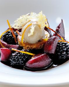 a white plate topped with fruit and ice cream on top of it's side