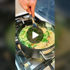 a person stirring food in a pot on the stove