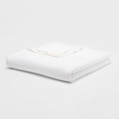 a folded white blanket on a white background