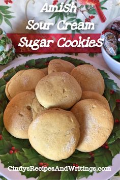 some sugar cookies are on a plate with holly wreaths around it and the words, amish sour cream sugar cookies