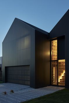 the exterior of a modern house with large windows and dark metal sidings on it