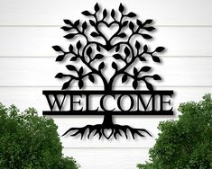 a metal sign that says welcome with a tree on it