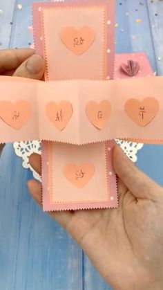 someone is holding up some pink cards with hearts on them and the words i love you