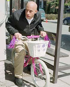 a man sitting on a bench next to a bike