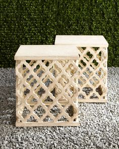 two small wooden boxes sitting next to each other on top of a gravel covered ground