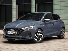 a grey car parked in front of a building