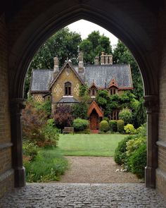 an archway leading to a house in the middle of a garden