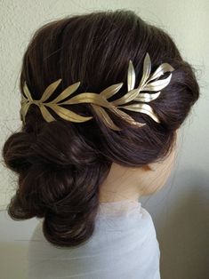 a woman wearing a gold leaf hair comb