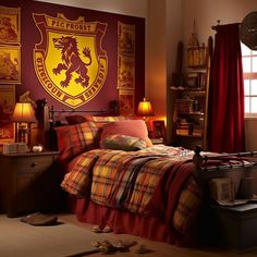 a bed room with a neatly made bed next to a red wall and a large hogwarts crest on the wall