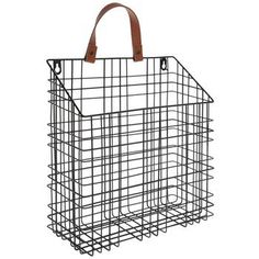 a wire basket with leather handles on the front and bottom, hanging from a hook