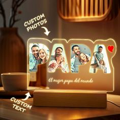 an illuminated photo frame with the word love in spanish and two pictures on it, sitting on a table next to a coffee cup