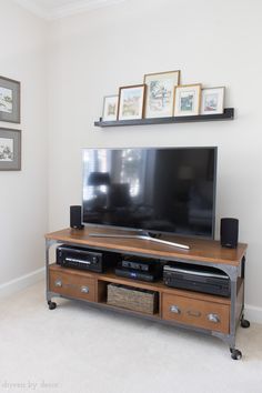 a flat screen tv sitting on top of a wooden entertainment center in a living room