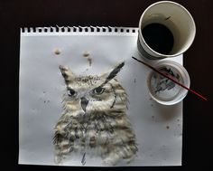 an owl drawn on top of a piece of paper next to a cup of coffee