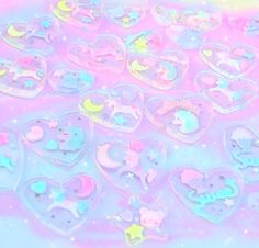 there are many heart shaped candies in the shape of animals and stars on this pink background