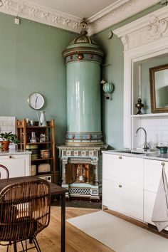 an old fashioned stove in the corner of a room with green walls and wood floors