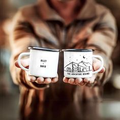 two people holding coffee mugs in their hands