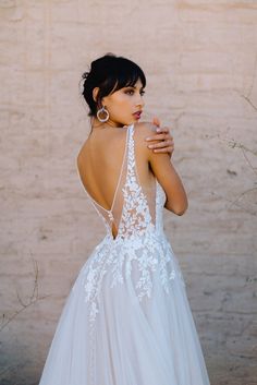 a woman wearing a wedding dress with an open back