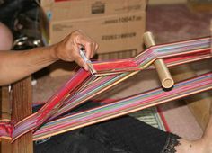 a woman is weaving fabric on a loom