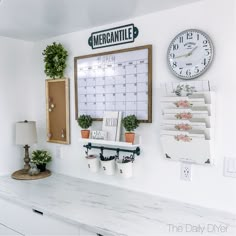 a white counter top sitting under a wall mounted clock and calendar on it's side