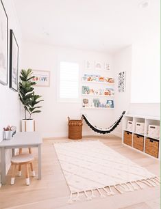 a hammock hanging in the corner of a room with white walls and wooden floors