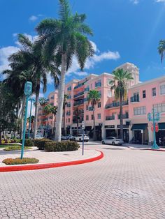 a pink building with palm trees in front of it