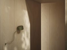 a room with wood paneling and a green lamp on the wall next to it