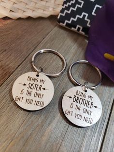 two metal key chains that say being my sister is the only gift you need