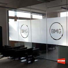 an office with glass partitions and logo on the wall