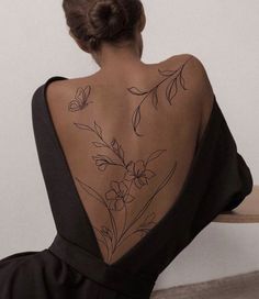 a woman sitting on a bench with her back turned to the side and flowers drawn on it