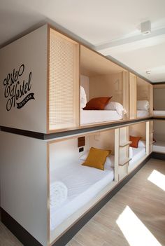 the bunk beds are built into the side of the wall and have pillows on them