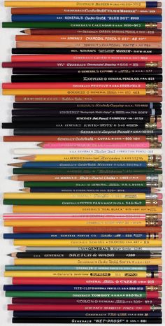 a bunch of different colored pencils are stacked on top of each other in rows