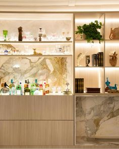 a marble counter top in a room with shelves filled with liquor bottles and vases