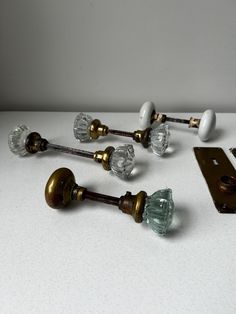 an assortment of glass knobs and handles on a white surface