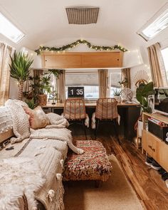 the interior of a camper with lots of plants and decorations on the bed area