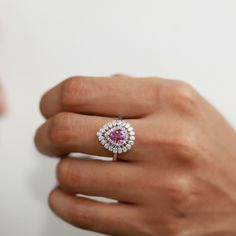 a woman's hand with a pink and white diamond ring