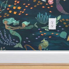 an image of a wall mural with mermaids and seaweed on it's side