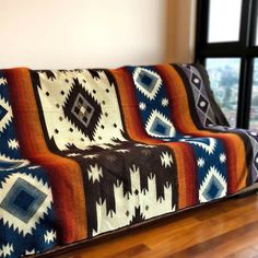 a couch with a blanket on it in front of a window